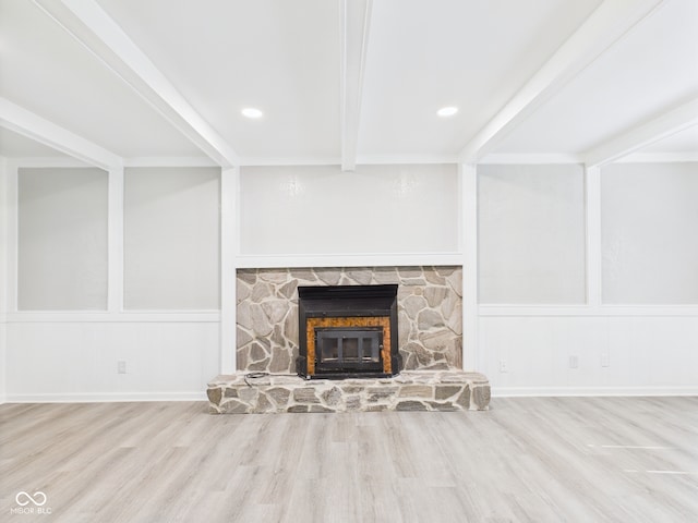 2126 Tartan Rd, Anderson, IN 46012 - unfurnished living room with a stone fireplace, beam ceiling, a decorative wall, wood finished floors, and recessed lighting