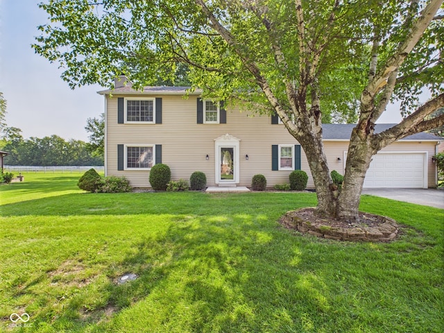 2126 Tartan Rd, Anderson, IN 46012 - colonial-style house featuring a chimney, a front lawn, driveway, and an attached garage