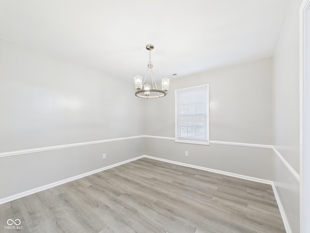 2126 Tartan Rd, Anderson, IN 46012 - unfurnished room with a chandelier and wood finished floors