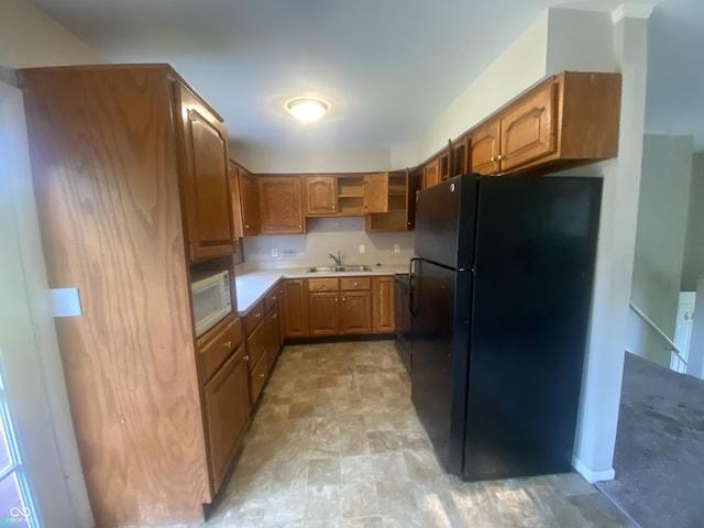 667 E Edgewood Ave, Indianapolis, IN 46227 - kitchen with freestanding refrigerator, white microwave, brown cabinets, light countertops, and open shelves