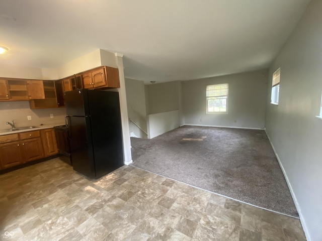 667 E Edgewood Ave, Indianapolis, IN 46227 - kitchen featuring freestanding refrigerator, light countertops, light carpet, brown cabinets, and open floor plan