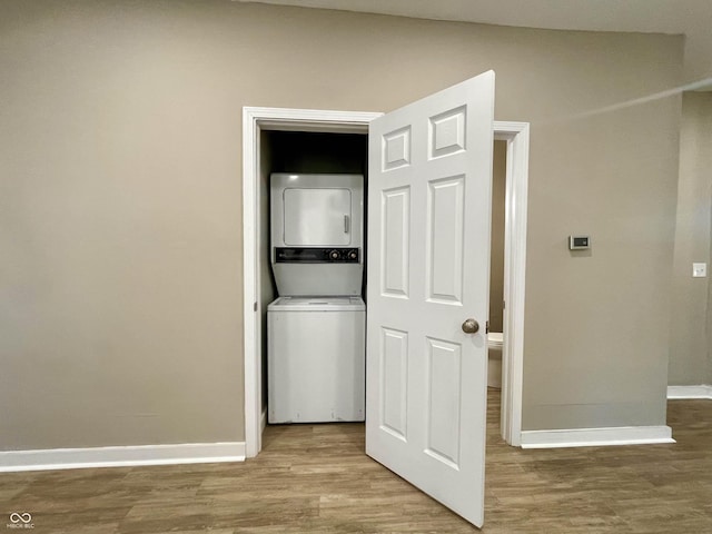 3835 N Kenwood Ave, Indianapolis, IN 46208 - washroom featuring stacked washer / dryer, baseboards, and wood finished floors