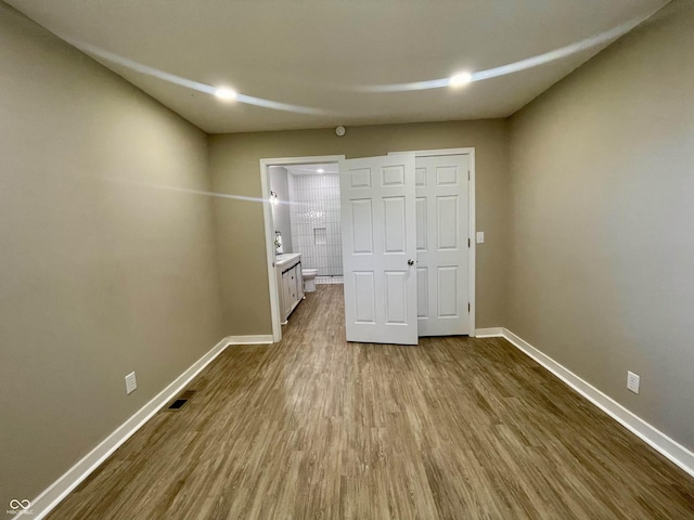 3835 N Kenwood Ave, Indianapolis, IN 46208 - unfurnished bedroom with baseboards, dark wood-style flooring, and ensuite bathroom