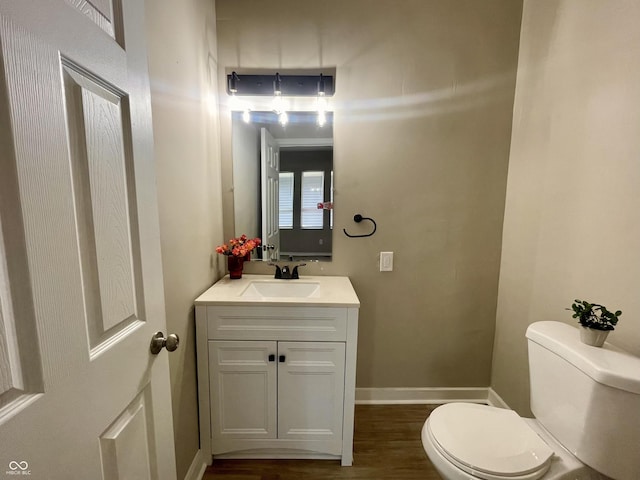 3835 N Kenwood Ave, Indianapolis, IN 46208 - half bathroom featuring toilet, vanity, and wood finished floors