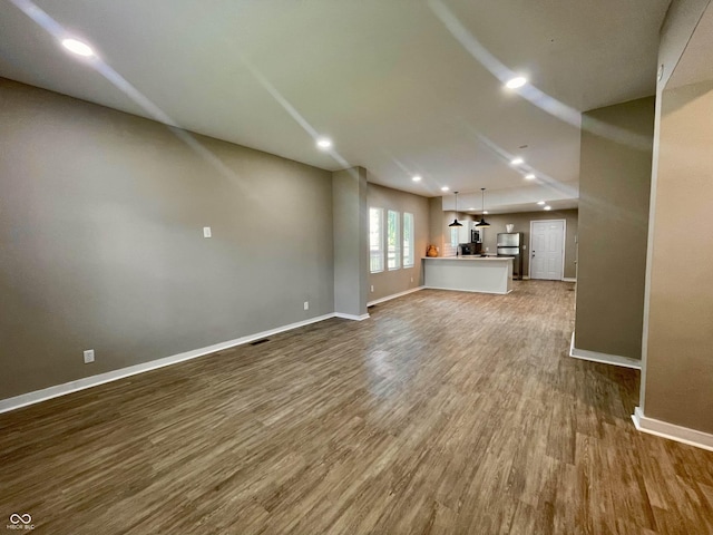 3835 N Kenwood Ave, Indianapolis, IN 46208 - unfurnished living room featuring baseboards, wood finished floors, and recessed lighting