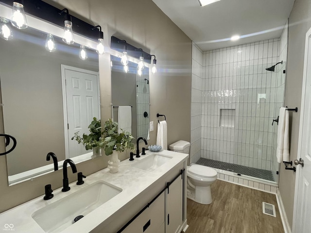 3835 N Kenwood Ave, Indianapolis, IN 46208 - bathroom featuring toilet, wood finished floors, double vanity, and tiled shower