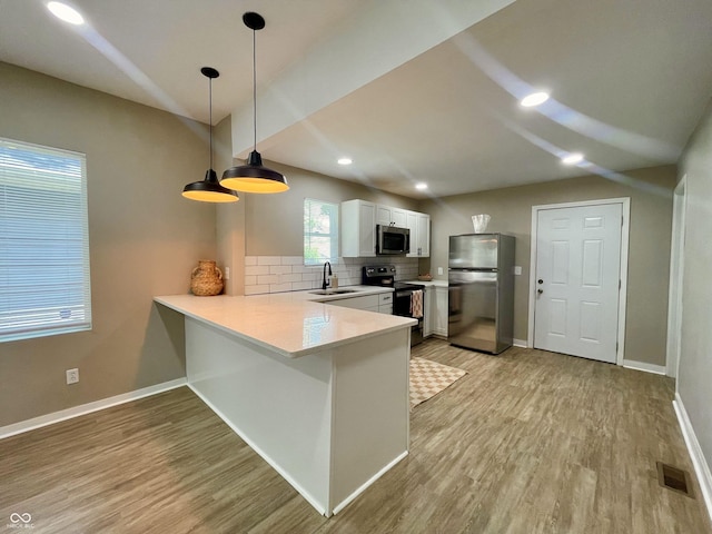 3835 N Kenwood Ave, Indianapolis, IN 46208 - kitchen with stainless steel appliances, a sink, a peninsula, decorative backsplash, and light wood-style floors