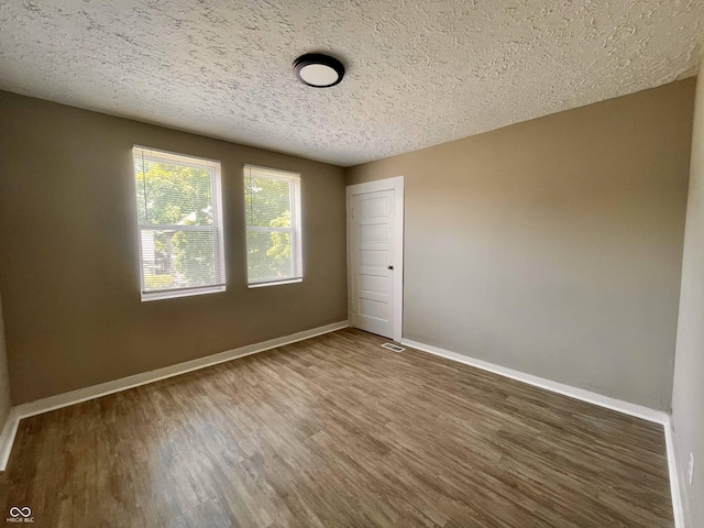 3835 N Kenwood Ave, Indianapolis, IN 46208 - unfurnished room with wood finished floors, a textured ceiling, and baseboards