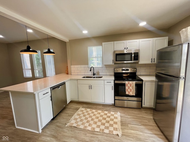 3835 N Kenwood Ave, Indianapolis, IN 46208 - kitchen with stainless steel appliances, a sink, a peninsula, light countertops, and tasteful backsplash