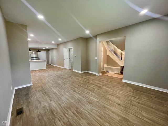3835 N Kenwood Ave, Indianapolis, IN 46208 - unfurnished living room featuring stairway, wood finished floors, recessed lighting, and baseboards