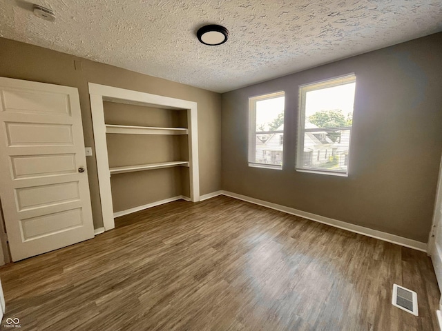 3835 N Kenwood Ave, Indianapolis, IN 46208 - unfurnished bedroom with a textured ceiling, a closet, wood finished floors, and baseboards