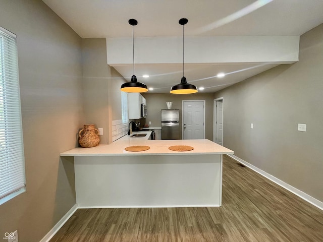 3835 N Kenwood Ave, Indianapolis, IN 46208 - kitchen featuring appliances with stainless steel finishes, a sink, dark wood finished floors, baseboards, and a peninsula