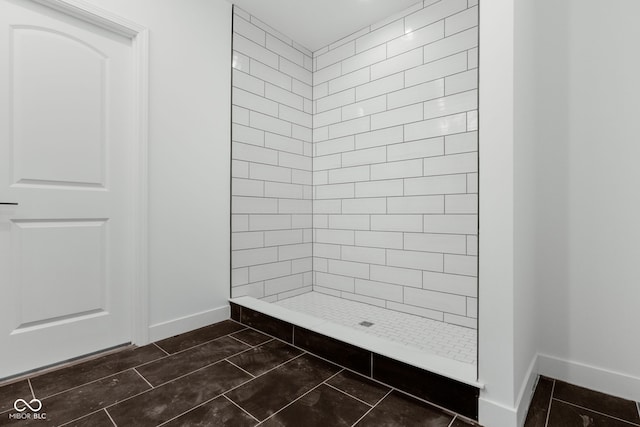 1409 N Grant Ave, Indianapolis, IN 46201 - full bathroom featuring baseboards and a tile shower