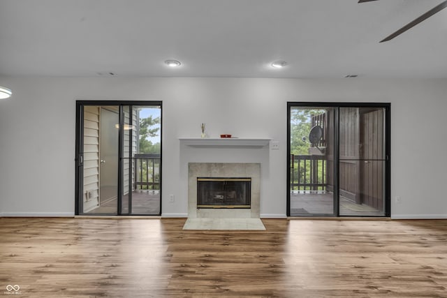 8176 Shorewalk Dr Unit C, Indianapolis, IN 46236 - unfurnished living room featuring wood finished floors, plenty of natural light, a tile fireplace, and recessed lighting