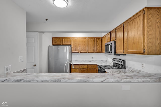 8176 Shorewalk Dr Unit C, Indianapolis, IN 46236 - kitchen featuring stainless steel appliances, light countertops, brown cabinets, and a peninsula