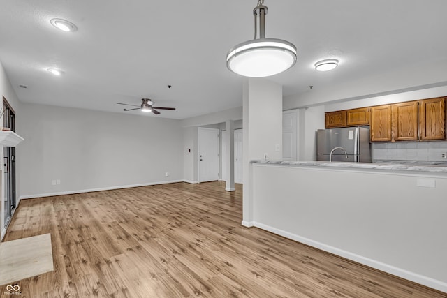8176 Shorewalk Dr Unit C, Indianapolis, IN 46236 - kitchen featuring freestanding refrigerator, brown cabinetry, a ceiling fan, and light wood-style floors