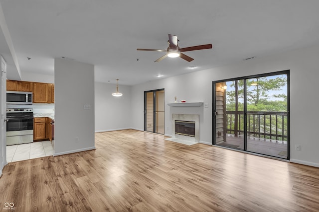 8176 Shorewalk Dr Unit C, Indianapolis, IN 46236 - unfurnished living room with light wood-style floors, ceiling fan, and a fireplace