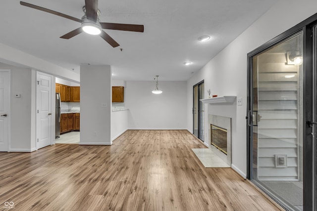8176 Shorewalk Dr Unit C, Indianapolis, IN 46236 - unfurnished living room with ceiling fan, a fireplace with flush hearth, and light wood-style floors