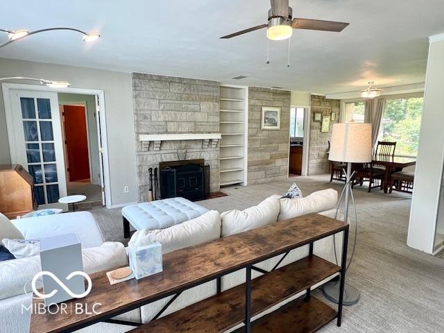 1802 Laurel Dr, Columbus, IN 47203 - living area with a ceiling fan, a stone fireplace, built in shelves, and light colored carpet