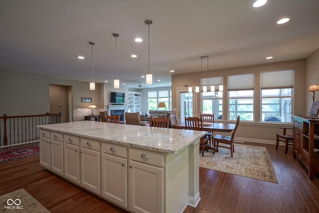 16209 Natures Way, Westfield, IN 46074 - kitchen featuring recessed lighting, dark wood-style flooring, a kitchen island, healthy amount of natural light, and hanging light fixtures