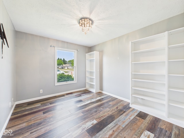 114 Bluebird Ln, Sulphur Springs, IN 47388 - spare room featuring a chandelier, wood finished floors, a textured ceiling, baseboards, and built in shelves