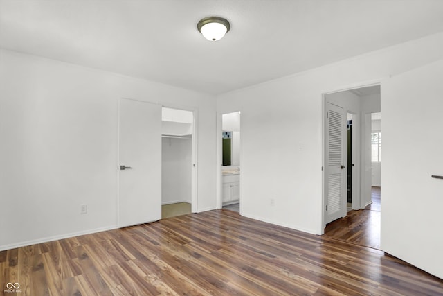 2642 Country Estates Dr, Indianapolis, IN 46227 - unfurnished bedroom with dark wood-type flooring, a closet, baseboards, a walk in closet, and connected bathroom