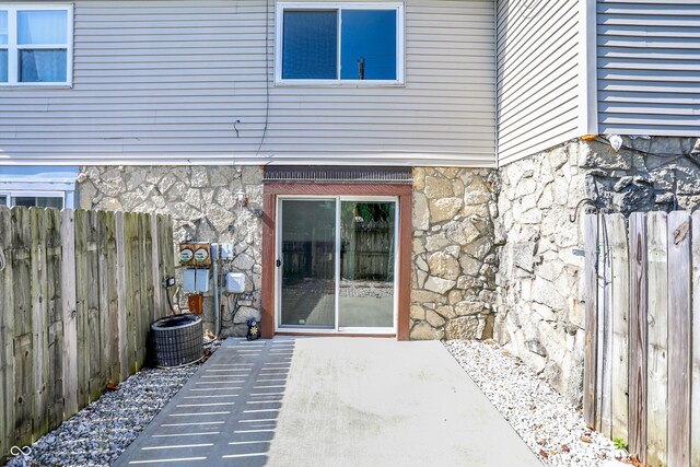 2642 Country Estates Dr, Indianapolis, IN 46227 - entrance to property featuring stone siding, a patio area, and central AC