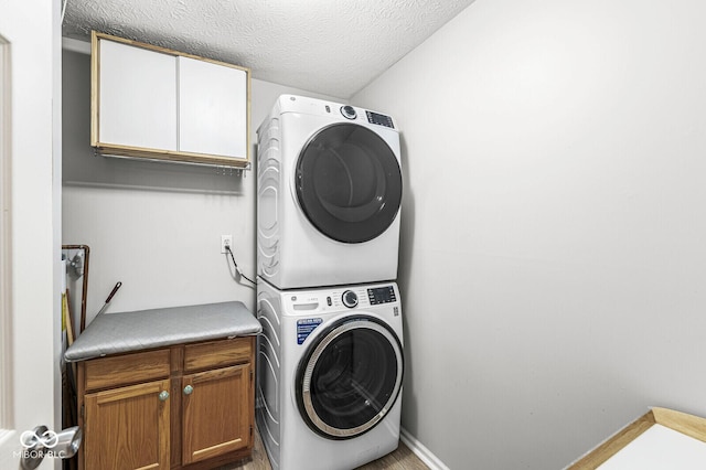 1044 Timber Creek Dr Unit 2, Carmel, IN 46032 - laundry area featuring cabinet space, estacked washer and dryer, and a textured ceiling