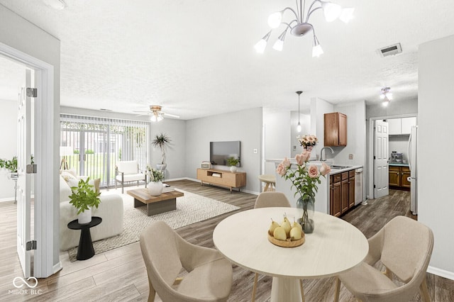 1044 Timber Creek Dr Unit 2, Carmel, IN 46032 - dining room with wood finished floors, a textured ceiling, ceiling fan, and a chandelier