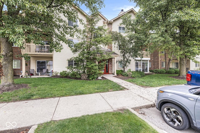1044 Timber Creek Dr Unit 2, Carmel, IN 46032 - view of front of house with a front yard, brick siding, and a balcony