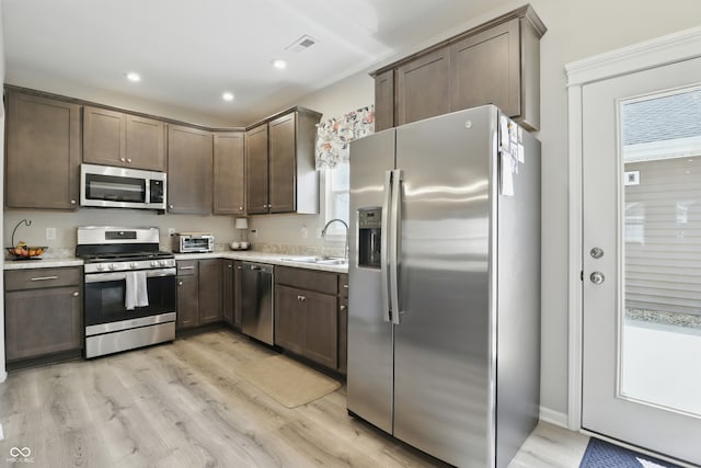 3613 Lehigh Ave, Westfield, IN 46074 - kitchen featuring appliances with stainless steel finishes, light countertops, dark brown cabinetry, light wood-type flooring, and recessed lighting