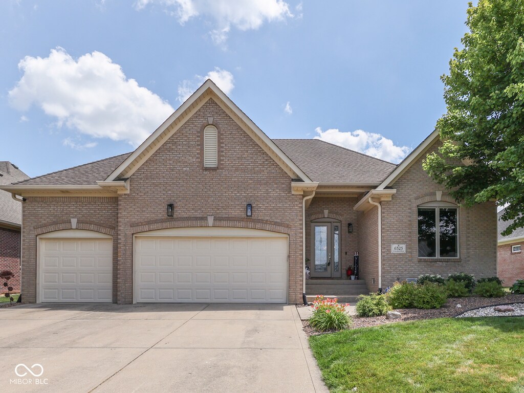6525 Carolina Blvd, Indianapolis, IN 46217 - view of front of house featuring driveway, brick siding, a garage, and a shingled roof