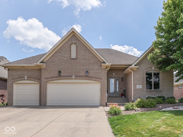 6525 Carolina Blvd, Indianapolis, IN 46217 - view of front of house featuring driveway, brick siding, a garage, and a shingled roof