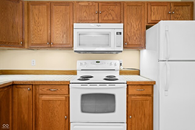5800 S Shore Dr, Nashville, IN 47448 - kitchen with white appliances, light countertops, and brown cabinetry