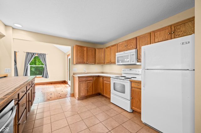 5800 S Shore Dr, Nashville, IN 47448 - kitchen featuring white appliances, light countertops, light tile patterned floors, and brown cabinets