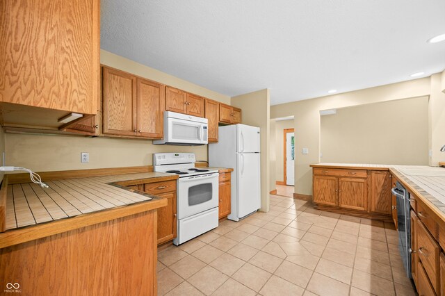 5800 S Shore Dr, Nashville, IN 47448 - kitchen with white appliances, tile counters, light tile patterned floors, recessed lighting, and brown cabinetry