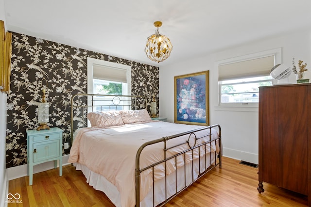 4813 E 11th St, Indianapolis, IN 46201 - bedroom with multiple windows, light wood-style floors, and a chandelier