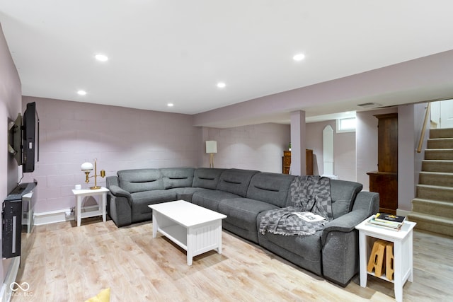 4813 E 11th St, Indianapolis, IN 46201 - living area with stairs, concrete block wall, light wood-style floors, and recessed lighting