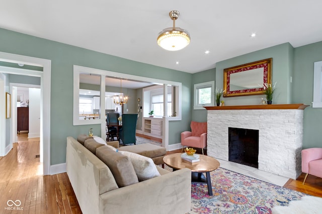 4813 E 11th St, Indianapolis, IN 46201 - living room featuring a chandelier, wood-type flooring, and a fireplace