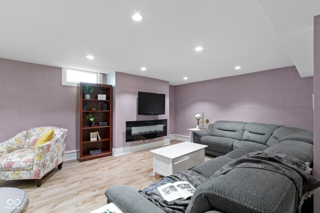 4813 E 11th St, Indianapolis, IN 46201 - living room with concrete block wall, light wood-style floors, and recessed lighting