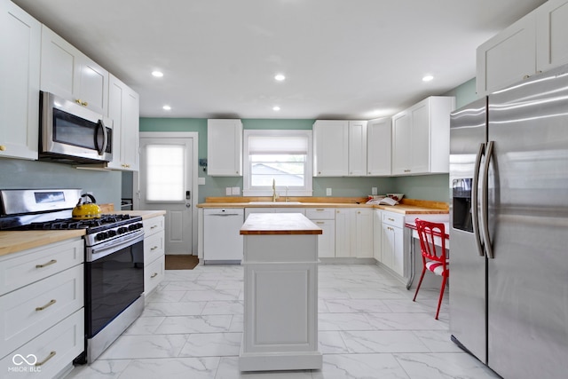 4813 E 11th St, Indianapolis, IN 46201 - kitchen featuring appliances with stainless steel finishes, wooden counters, light marble finish floors, recessed lighting, and a kitchen island