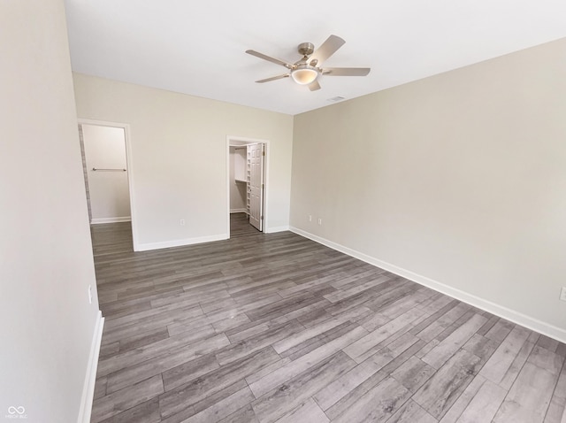1359 Shadow Ridge Rd, Indianapolis, IN 46280 - unfurnished bedroom featuring wood finished floors, baseboards, a walk in closet, a closet, and ceiling fan