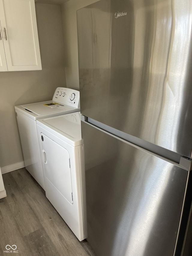 880 N Avon Ave, Avon, IN 46123 - laundry room featuring separate washer and dryer, light wood-style floors, and cabinet space