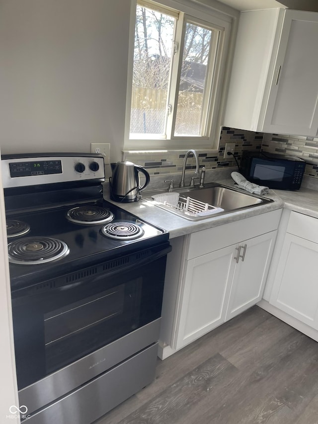 880 N Avon Ave, Avon, IN 46123 - kitchen with stainless steel electric range oven, black microwave, white cabinets, decorative backsplash, and dark wood-style flooring