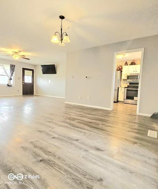 731 Sunset Blvd, Greenwood, IN 46142 - unfurnished living room with light wood-type flooring, baseboards, a chandelier, and a ceiling fan
