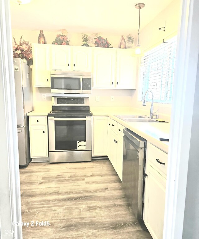 731 Sunset Blvd, Greenwood, IN 46142 - kitchen featuring stainless steel appliances, a sink, light wood finished floors, and white cabinets