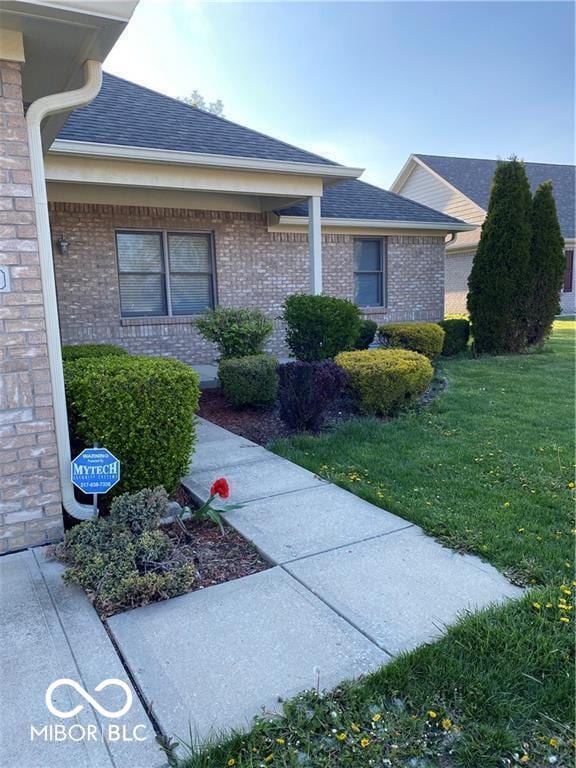 1128 Brookside Ct, Avon, IN 46123 - view of home's exterior featuring a yard, a shingled roof, and brick siding