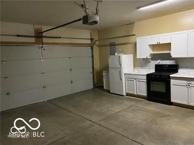 1128 Brookside Ct, Avon, IN 46123 - garage with freestanding refrigerator and a garage door opener