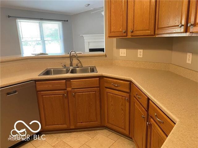1128 Brookside Ct, Avon, IN 46123 - kitchen with stainless steel dishwasher, light countertops, brown cabinets, light tile patterned floors, and a fireplace