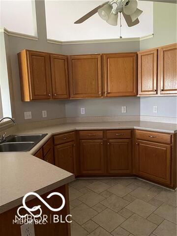 1128 Brookside Ct, Avon, IN 46123 - kitchen with a ceiling fan, brown cabinetry, and light countertops